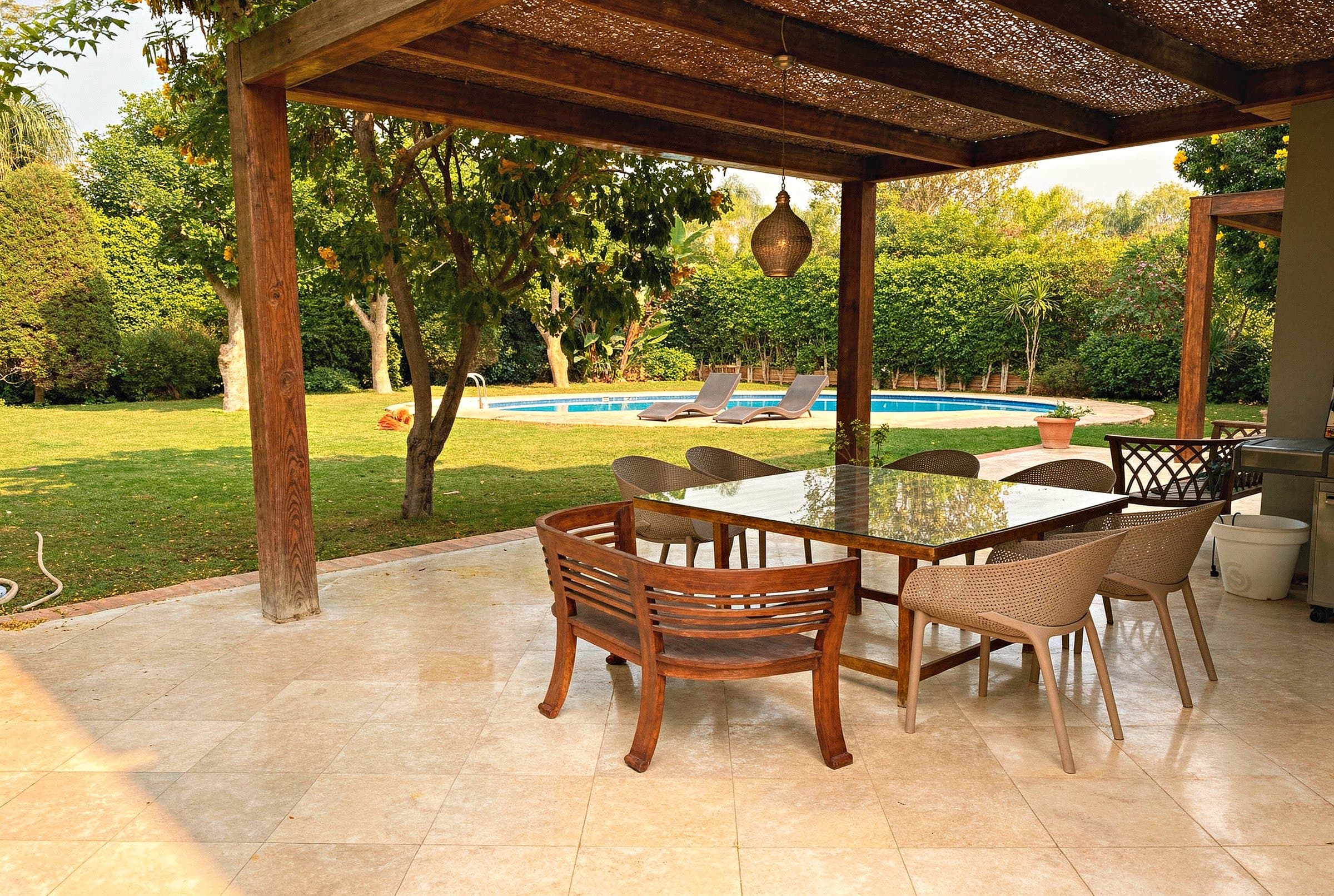 Covered terrace dining and lounge area by the pool