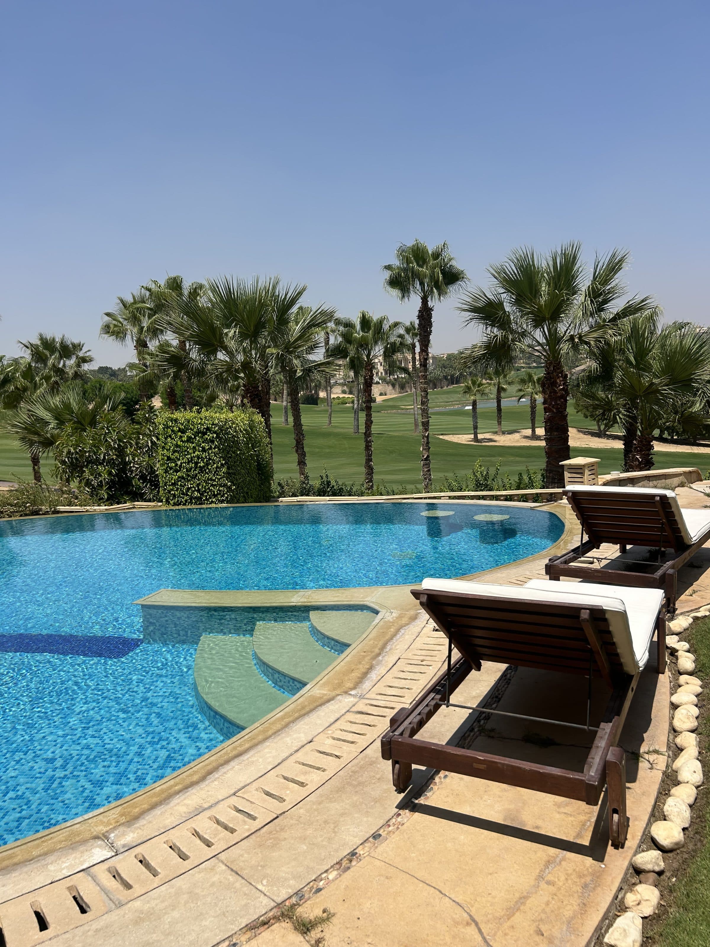 Villa pool opening onto the Katameya Heights golf course fairway